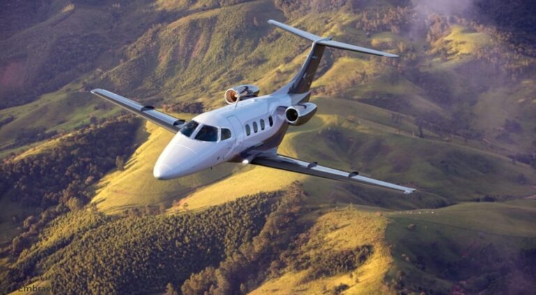 an embraer phenom 100 flying over hillsides, seen from above